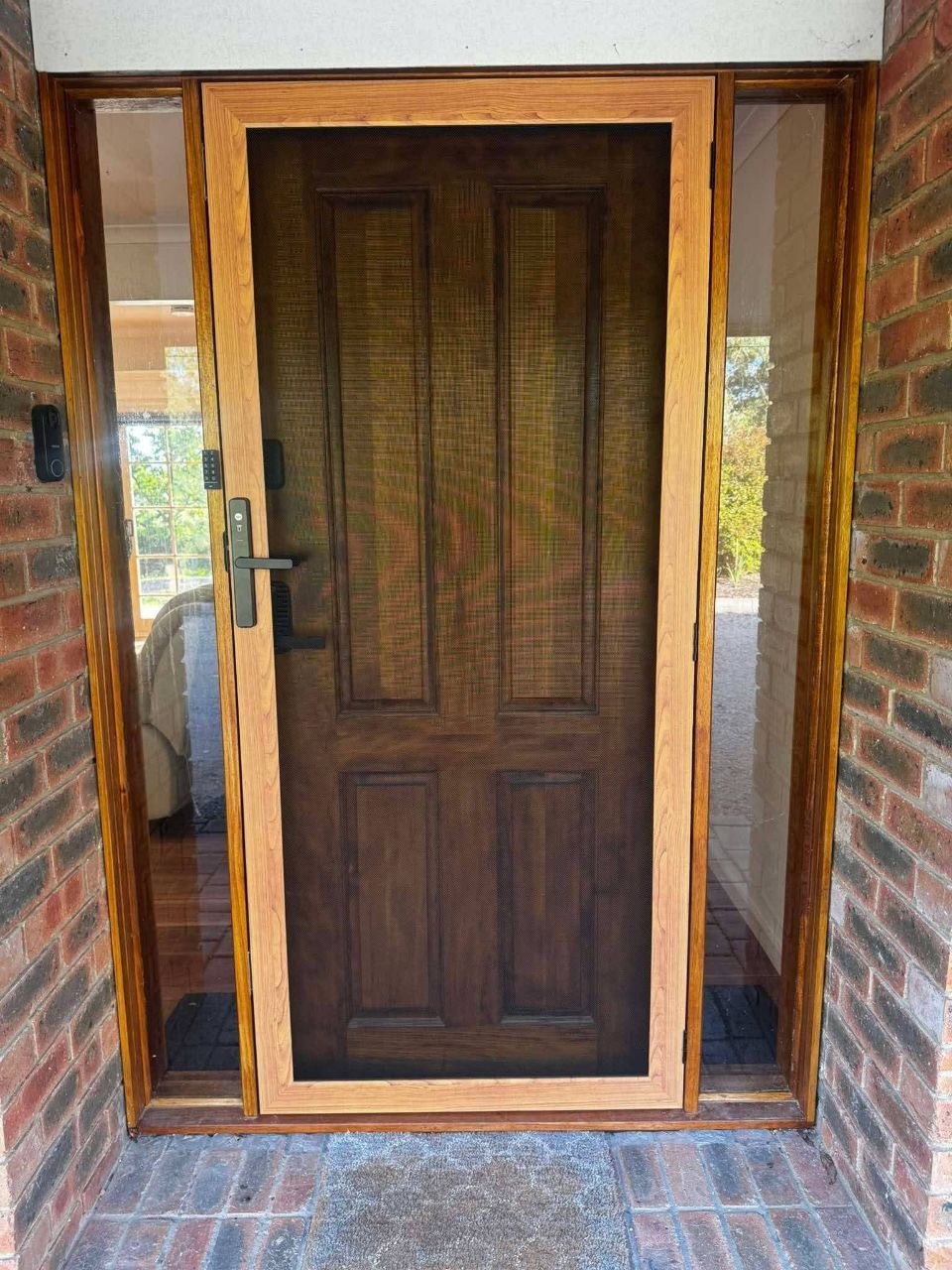 Timber wood finish security door fitted at brick entrance